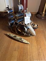 Photo showing all three ship models on wooden floor with lighting from left side.