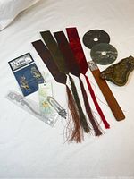 Full view of all items including four bookmarks, stone disks, wooden bookmark with charm, bird pins, clear plastic bookmark, and metal elephant charm.