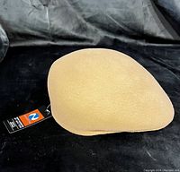 Side view of the camel colored hat showing its shape and texture.