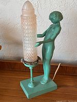 Full view of lamp showing nude figure, base, and shade