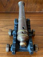 Front view of bronze barrel and black iron carriage mounted on brass-rimmed wheels