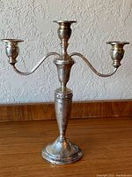 Front view of complete three-arm candelabra showing overall form and structure