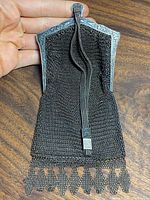 Photo showing the front side of the antique sterling silver mesh evening bag, including the lightly decorated frame and mesh body with fringed edge.