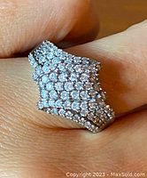Close-up of ring head showing multi-row pave-set round diamonds in a geometric cluster