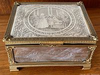 Overall three-quarter view showing engraved lid, gilt bronze frame and feet