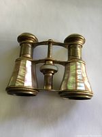 Top view of antique opera glasses showing mother of pearl inlay and brass body.