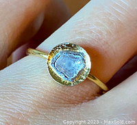 Close-up top view of old mine cut diamond set in gold gilt bezel on slender band.