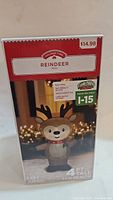 Box front showing Holiday Time Reindeer Inflatable, 4 feet tall, with LED lights, suitable for indoor/outdoor use.