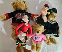 Photo showing assorted plush dolls and bears including pirate bear, Popeye figure, and bears in various outfits