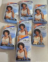 Seven unopened packages of Playtex 18 Hour bras, white color, size 48C, laid out for display.