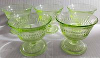 Five vintage uranium glass sherbet cups arranged in a group showcasing their general shape and color.