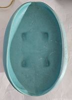 Top view of oval turquoise McCoy Pottery flower bowl showing interior and base with foot pads.