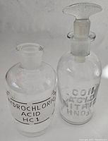 Photo showing both acid bottles side by side, one with stopper, one without.