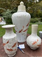 Photo of the three porcelain vases together showing size and design details including koi fish and lily pads