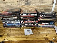 Photo of 35+ assorted DVD cases stacked, showing titles and general condition