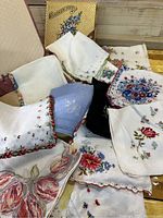 Image showing a pile of 14 vintage handkerchiefs with various floral embroidery and a vintage box.