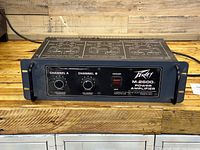 Front view of Peavey M-2600 power amplifier showing control knobs, power switch, and branding.