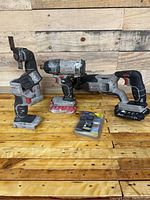 Front view of 3 Porter Cable cordless power tools with lithium batteries and two accessory packages on a wooden surface.