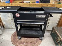 Front view of black Craftsman rolling tool cart with closed top trays and two drawers below