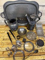 Full view of all silver plated items including the large tray, pitchers, small bowl, serving utensils and decorative items.