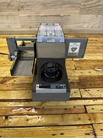 Front view of the Bell and Howell slide projector showing the lens, slide tray, and branding details.