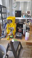 Full view of the lot on a workbench including caulk gun, chalk line, router, torch, and other tools