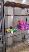 Front view of metal wire shelving unit with some contents placed on lower shelves (not included in lot).