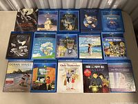 15 Blu-ray cases arranged in three rows on metal surface