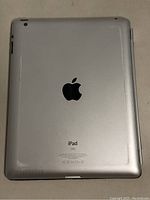 Back of the Apple iPad showing silver aluminum finish and Apple logo with iPad branding.