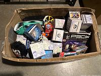 Overview of various collectible boxes, sneaker, and plush toy in cardboard box