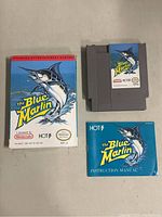 Original boxed Nintendo NES The Blue Marlin game with cartridge and instruction manual laid out together showing front artwork.