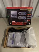 Original retail box displayed behind console and accessories in box.