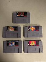 Photo showing five SNES cartridges with reproduction labels for various games.
