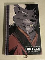 Front cover of the hardcover graphic novel featuring an anthropomorphic rat character in a robe.