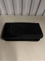 Closed black zippered Wii game binder on a white surface