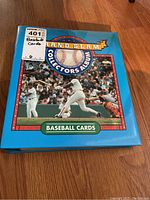 Blue Hard Slam Collectors Album binder with baseball image and text 'Baseball Cards' on front cover, closed, showing some wear on edges.