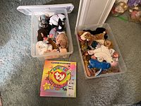 Photo showing two plastic bins filled with assorted Ty Beanie Babies with visible Ty tags, and the Official Ty Beanie Babies Club membership kit placed in front.