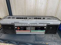 Front view of Sony CFS-W30 boombox showing dual cassette decks, speakers, buttons, and stereo tuner scale.