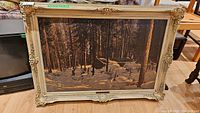Full view of vintage print "Shack in the Woods" inside its ornate cream wood frame with visible carvings.