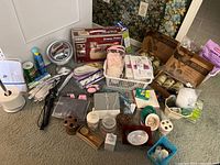 Full lot overview showing hair care bottles, personal care and health items, Shiatsu pillow, curling iron, soap dishes, and more.