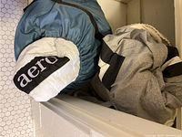 Photo showing the folded air mattress and covers with 'aero' logo visible on white and blue covers.