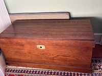 Full front view of cedar chest showing stained wood exterior and brass lock plate