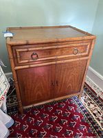Front angle showing entire nightstand with bamboo detailing and drawer above cabinet doors
