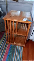 Image of wood rotating bookcase showing side vertical slats and interior shelves.