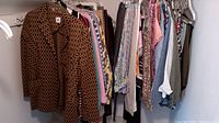 Photo showing a rack of women's clothing including pants, tops, and jackets in various colors and patterns.