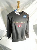Front view of black San Francisco 49ers sweatshirt showing logo and text
