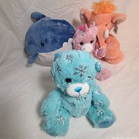 Four animal plush dolls shown together on neutral background, includes whale, bear, mammoth, and unicorn.