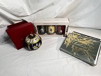 Neiman Marcus ornament in front with red box, Yankee Candle Christmas gift set with three candles, two boxed Christmas greeting cards in gold and red/green