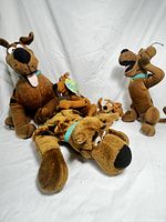 Grouped view of all five Scooby-Doo plush toys arranged on white backdrop showing size and condition