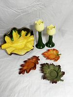 Set of 6 fall inspired items including 2 tulip-shaped candle holders, 3 leaf-shaped candle holders in autumn colors, and one leaf-shaped decorative ceramic dish.